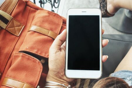 Woman using smart phone with bagの写真素材