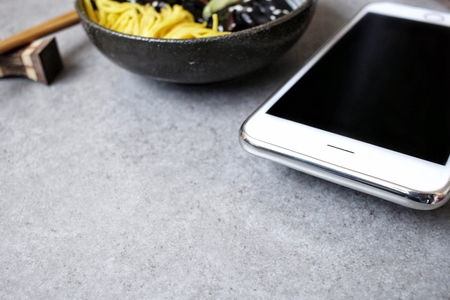 Korean black bean noodle jajangmyeon with smart phoneの写真素材