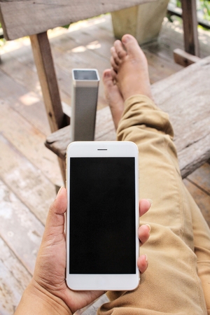 Woman listening to music on bluetooth speaker with smart phoneの写真素材