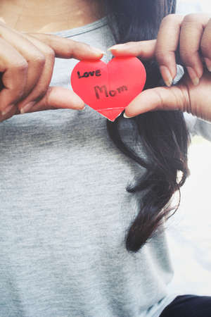 Woman with heart mom on handの写真素材