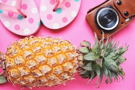 Pineapple and flip flop on pink background in summerの写真素材