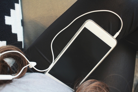 Smart phone and earphones on handの写真素材