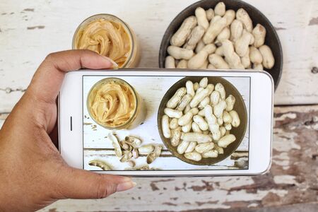 Taking a photo of peanut butter with smart phoneの写真素材