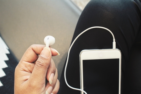 Smart phone and earphones on handの写真素材