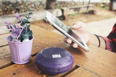 Woman using smart phone with wireless speakerの写真素材