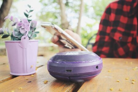Woman using smart phone with wireless speakerの写真素材