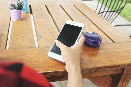 Woman using smart phone with wireless speaker