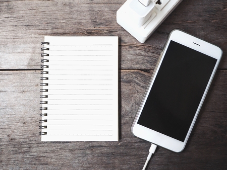 Smartphone charger with blank notepadの写真素材
