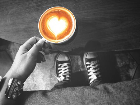 Selfie of woman drinking coffee with sneakersの写真素材