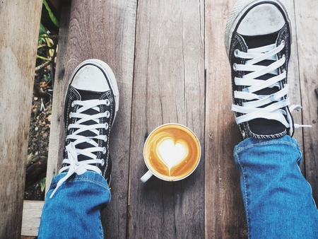 Selfie of latte art coffee with sneakersの写真素材