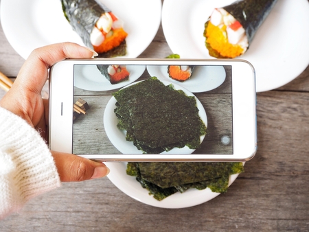 Taking a photo of korean seaweed with sushi and smart phoneの写真素材