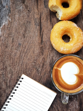 Coffee and donut with blank notepadの写真素材
