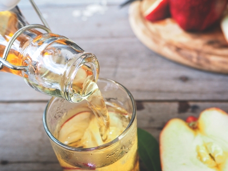 Woman pouring apple juiceの写真素材