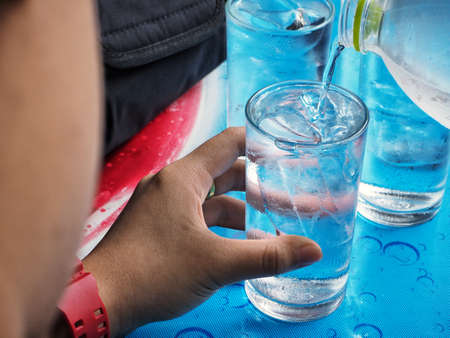 Pouring water into glassの写真素材