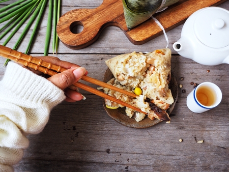 Woman eating zongzi chinese foodの写真素材