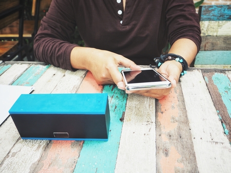 Woman using bluetooth speaker with smart phoneの写真素材