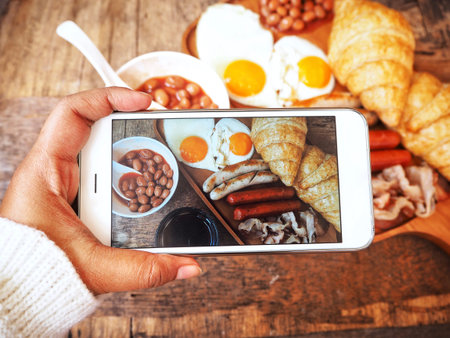 Taking a photo of english breakfast with smart phoneの写真素材