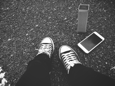 Selfie of woman using wireless speaker with smart phone on streetの写真素材
