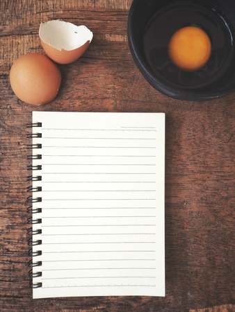 Egg in a bowl with blank notepadの写真素材