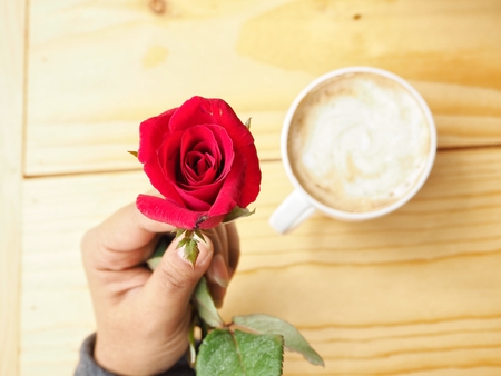 Woman drinking coffee cup and red rose in valentines dayの写真素材