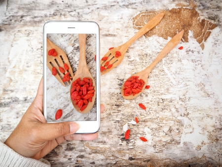 Taking a photo of dried goji berries with smart phoneの写真素材