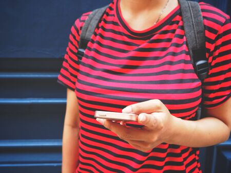 Woman traveling with backpack and using smart phoneの写真素材