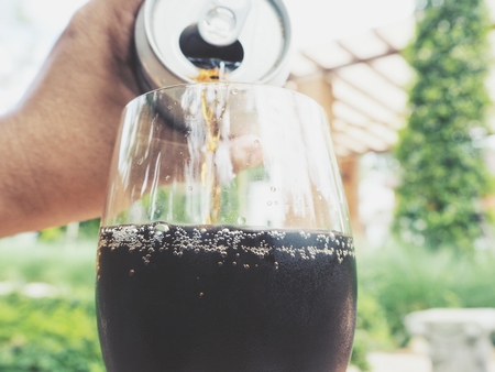 Woman pouring cola drinkの写真素材