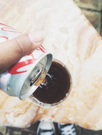 Woman pouring cola drinkの写真素材