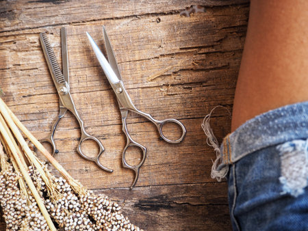 Leg of woman and hair cutting shears with dried flowers