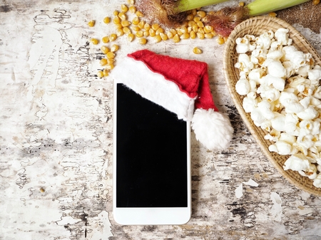 Smart phone with christmas hat and popcornの写真素材