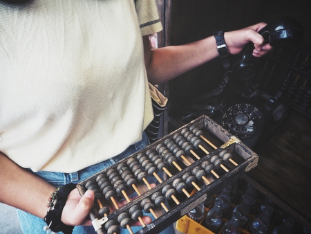 Woman with abacus and antique telephoneの写真素材