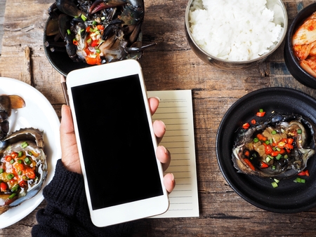 Smart phone with soy sauce marinated crab Korean foodの写真素材