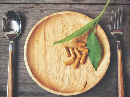 Turmeric capsules with fork and spoonの写真素材