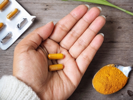 Turmeric capsules on handの写真素材