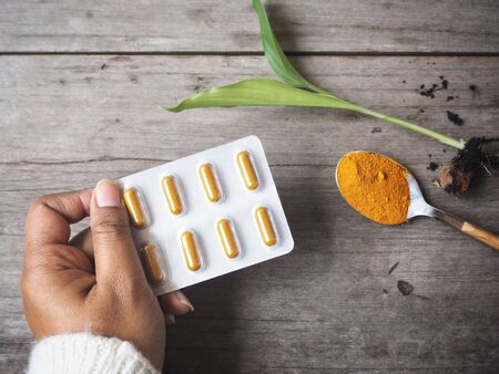 Turmeric capsules on handの写真素材