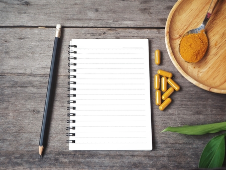 Turmeric capsules with blank notepadの写真素材