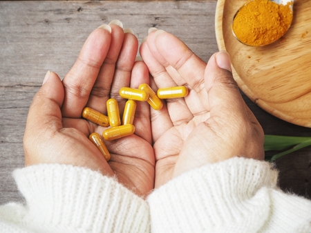 Turmeric capsules on handの写真素材