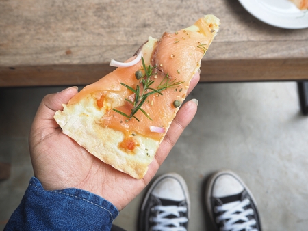 Smoked salmon pizza on handの写真素材