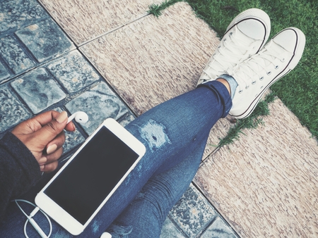 Selfie of smart phone and headphones with shoesの写真素材