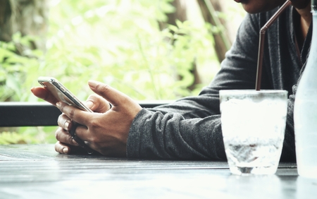 Woman using smart phone with water drinkの写真素材
