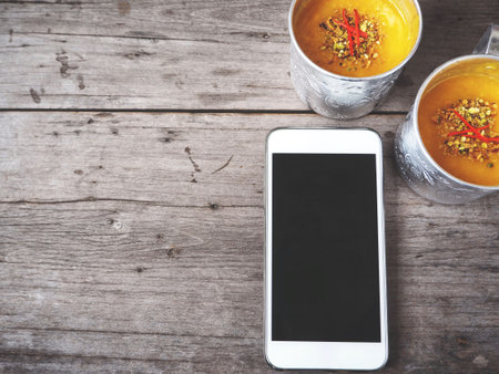 Smart phone with mango lassi Indian drink