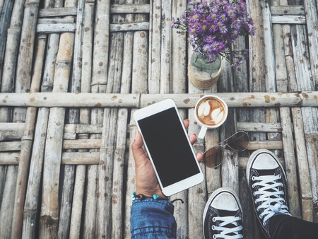Selfie of shoes with smart phone and coffee cupの写真素材