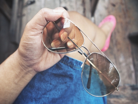 Selfie of sun glasses on hand with shoesの写真素材