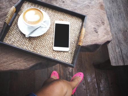 Woman drink coffee with smart phoneの写真素材