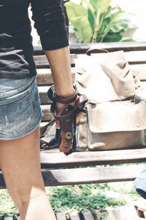 Woman traveling with backpack and camera on hand