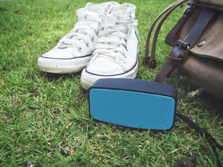 Travel accessories of bluetooth speaker with sneakers and bagの写真素材