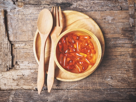 Cod liver oil capsules with fork and spoonの写真素材