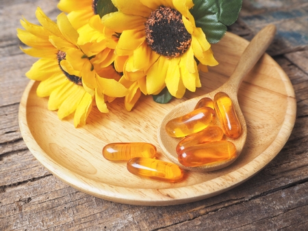 Cod liver oil capsules with flowersの写真素材