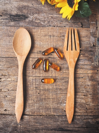 Cod liver oil capsules with fork and spoonの写真素材