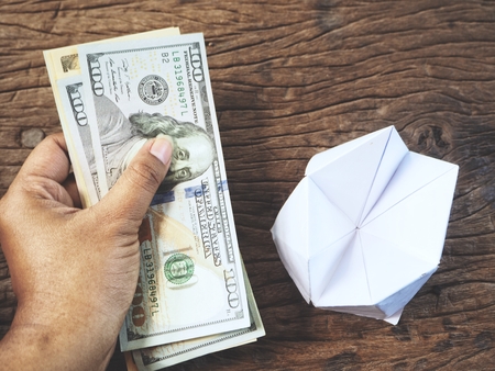 Dollars on hand with paper fortune tellerの写真素材